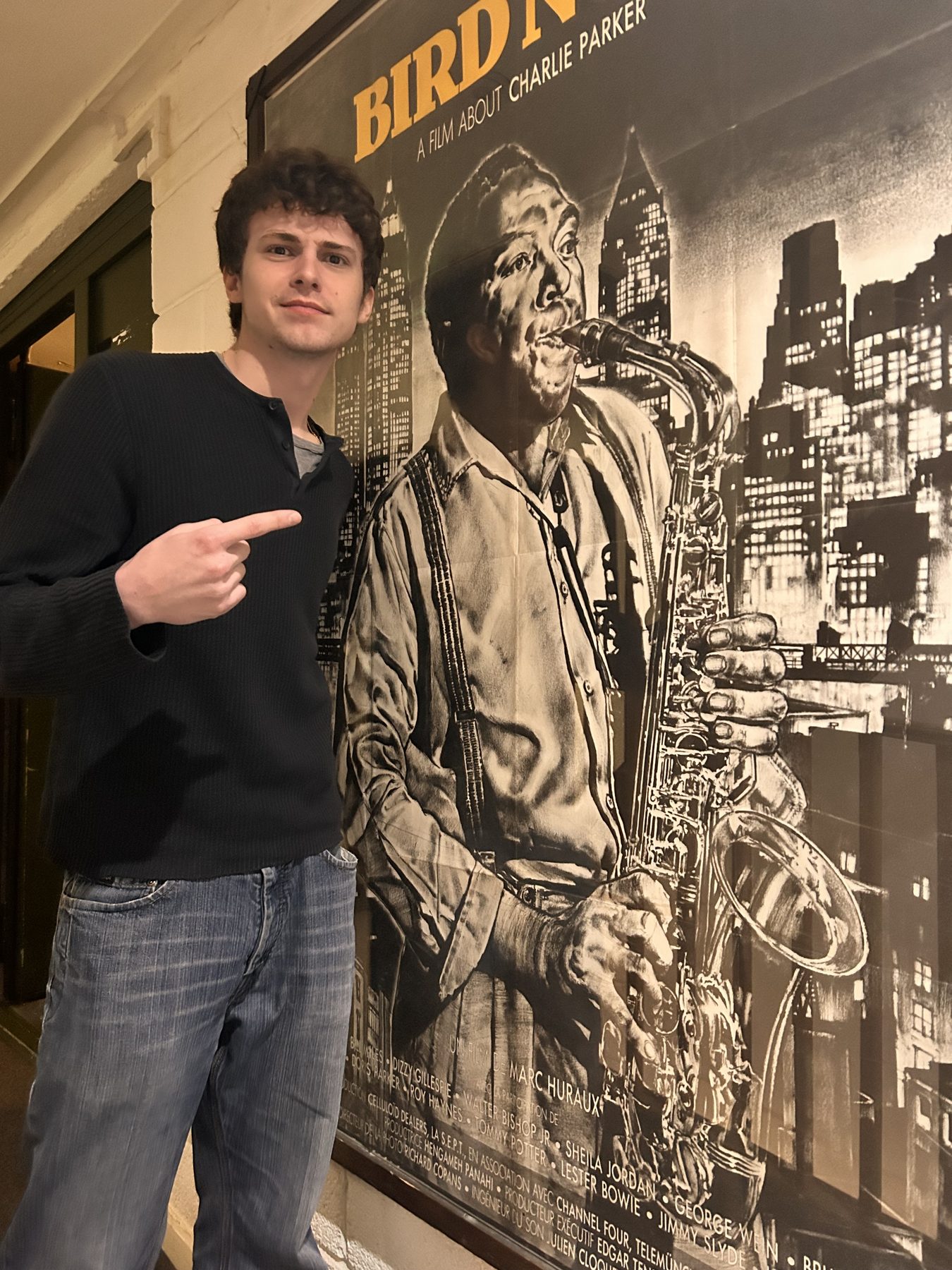 Andrea de Selancy beside a Charlie Parker poster.